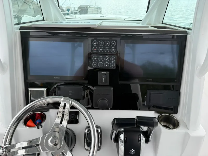 Slide: The Image of 2025 Stingray 273 CC boat dashboard with dual Garmin screens and modern controls. - 16