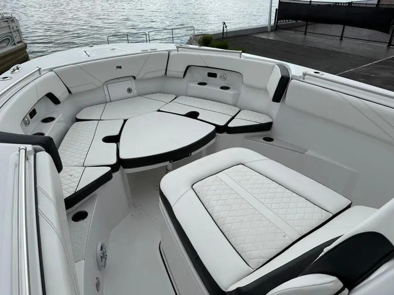 Slide: The Image of 2025 Stingray 273 CC boat interior with luxurious white seating and waterfront view. - 28