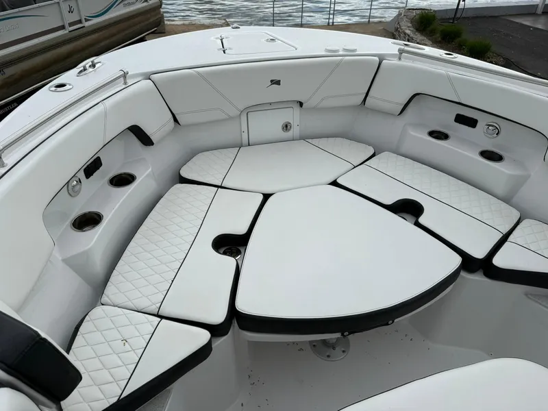 Slide: The Image of 2025 Stingray 273 CC boat interior with white cushioned seating and cup holders. - 29