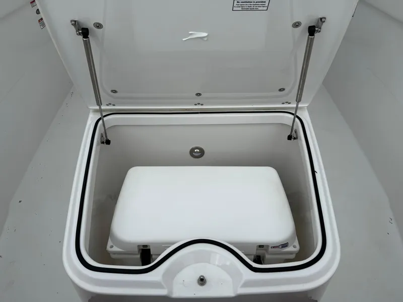 Slide: The Image of Open storage compartment in 2025 Stingray 273 CC boat, featuring a white interior. - 32