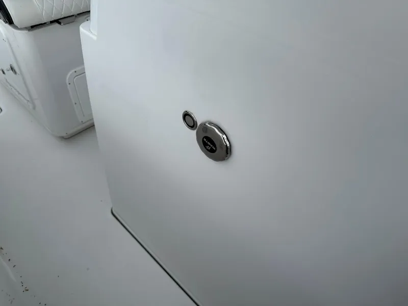 Slide: The Image of 2025 Stingray 273 CC boat interior detail with sleek white panel and control button. - 34