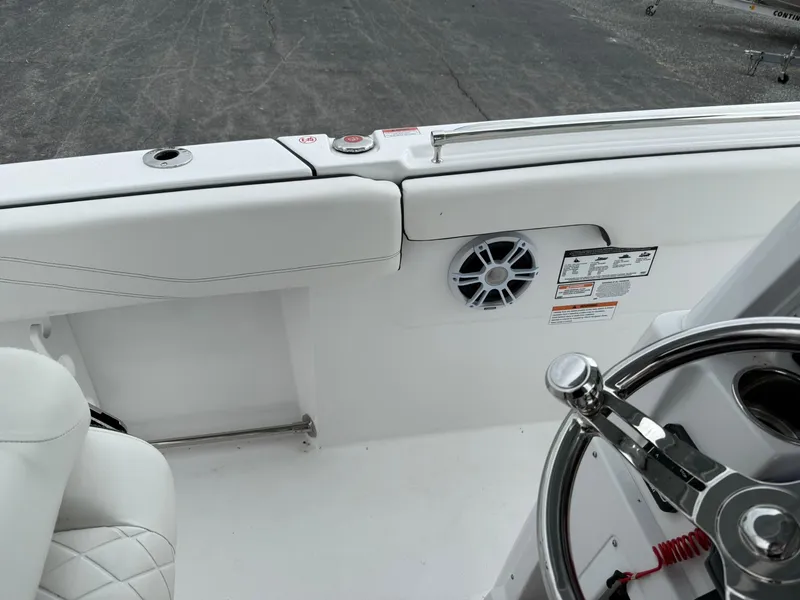 Slide: The Image of 2025 Stingray 273 CC boat interior with steering wheel and speaker detail. - 35