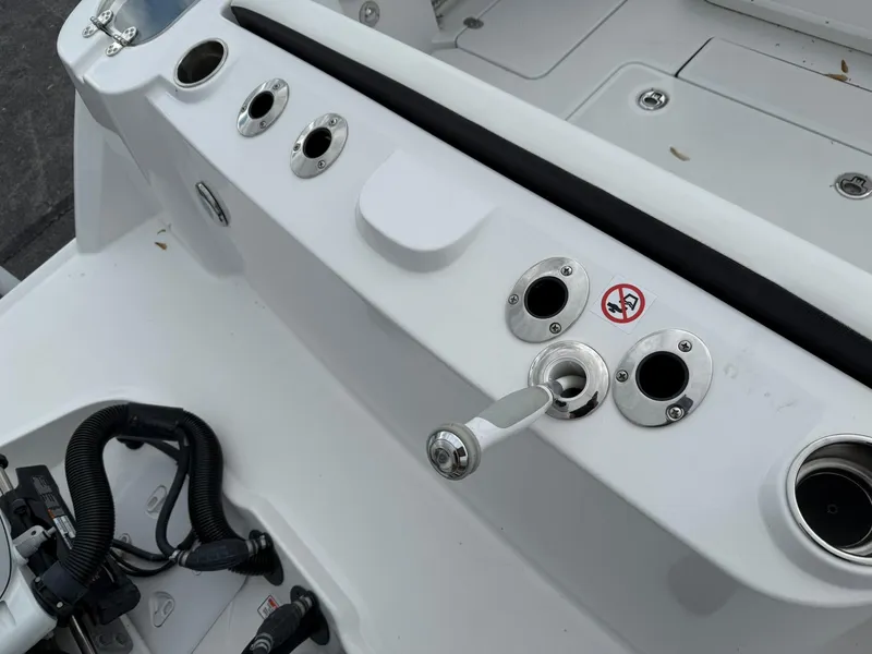 Slide: The Image of 2025 Stingray 273 CC boat deck with rod holders and control lever. - 9