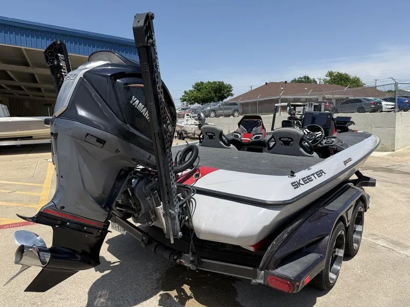 Slide: The Image of 2023 Skeeter FXR21 Limited boat with Yamaha engine, parked on a trailer in a sunny lot. - 11