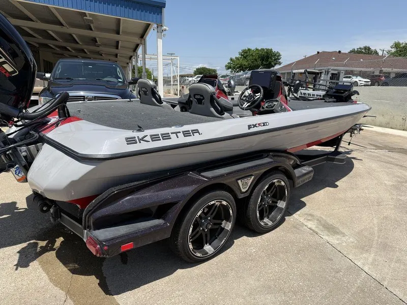 Slide: The Image of 2023 Skeeter FXR21 Limited boat on trailer, parked outdoors under clear sky. - 12