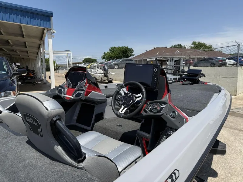 Slide: The Image of 2023 Skeeter FXR21 Limited boat interior with advanced dashboard and seating, parked outdoors. - 13