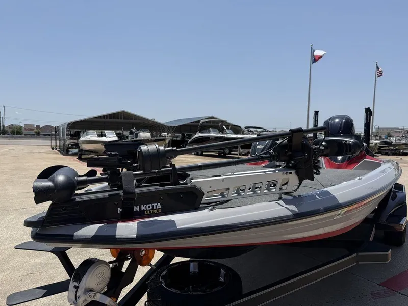 Slide: The Image of 2023 Skeeter FXR21 Limited boat with Minn Kota Ultrex motor, parked outdoors. - 2