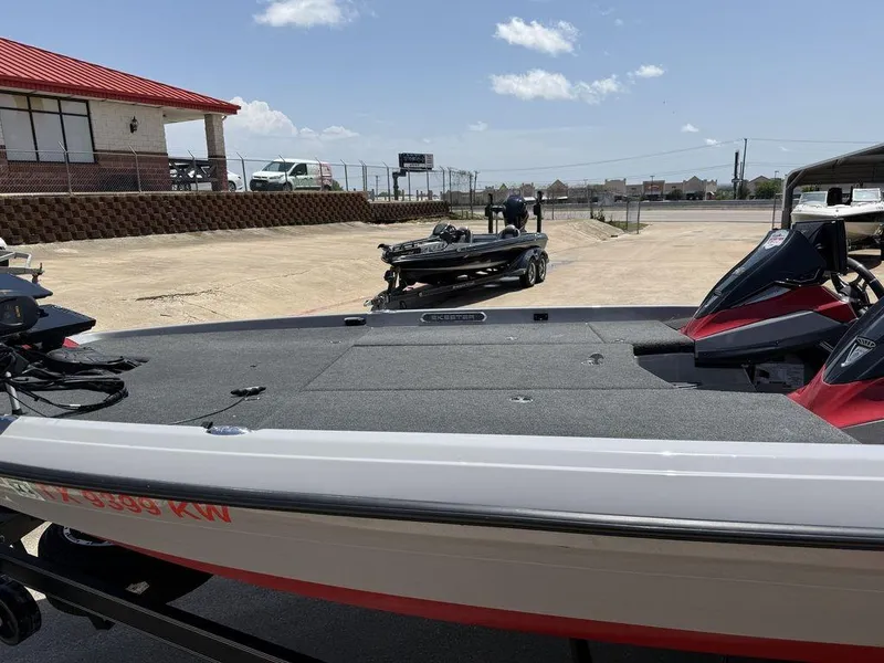 Slide: The Image of 2023 Skeeter FXR21 Limited boat on trailer, parked outdoors under clear sky. - 5