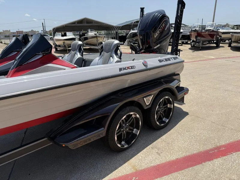 Slide: The Image of 2023 Skeeter FXR21 Limited boat on trailer, displayed outdoors in a dealership lot. - 6