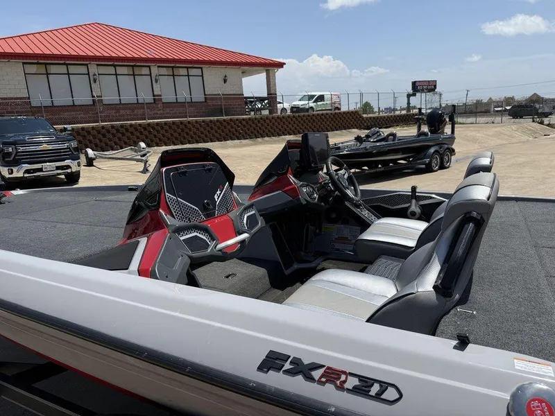 Slide: The Image of 2023 Skeeter FXR21 Limited boat with modern interior, parked outdoors under clear skies. - 8