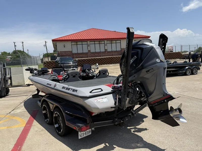 Slide: The Image of 2023 Skeeter FXR21 Limited boat on trailer, parked outdoors under clear sky. - 9