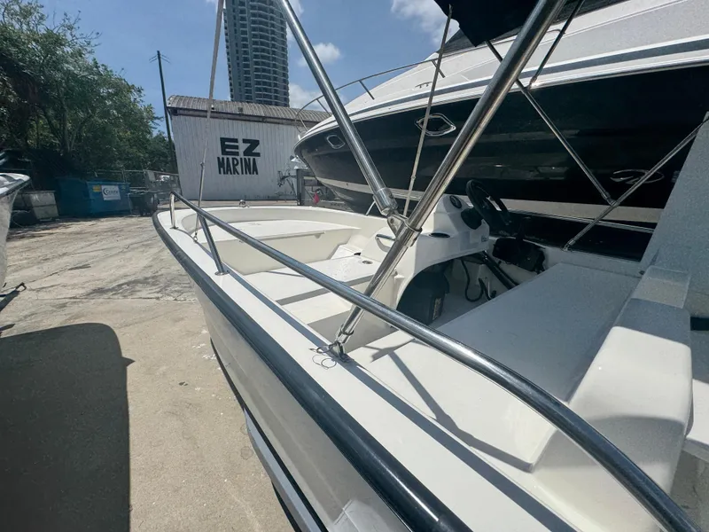 Slide: The Image of 2004 Boston Whaler 150 Sport boat docked at EZ Marina under a clear sky. - 5