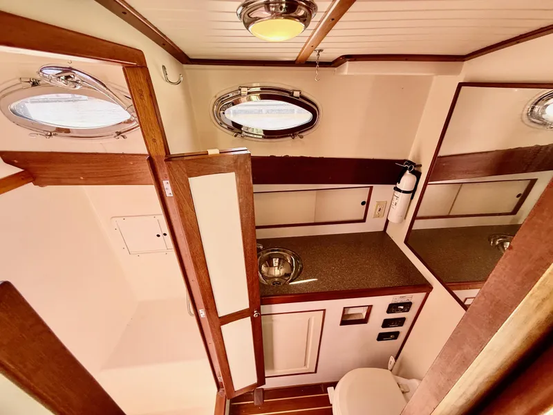 Slide: The Image of Interior of 2006 Mast & Mallet Thomas Point 40 boat, featuring wooden cabinetry and porthole windows. - 39
