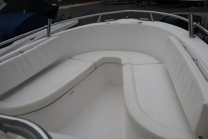 Slide: The Image of 2004 Edgewater 225CC boat interior with white cushioned seating. - 12