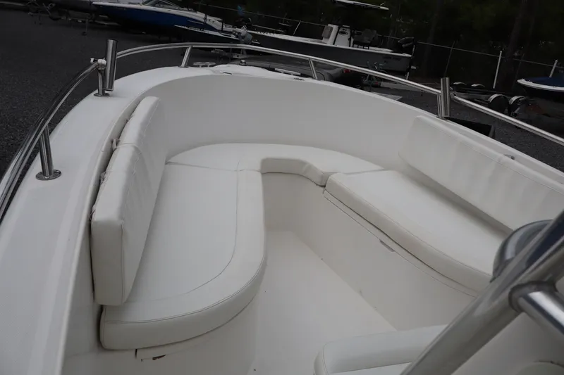 Slide: The Image of 2004 Edgewater 225CC boat interior with white cushioned seating. - 13