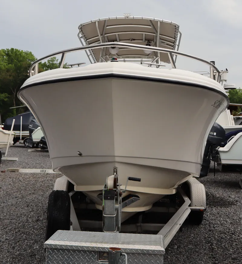 Slide: The Image of 2004 Edgewater 225CC boat on trailer, front view, parked on gravel. - 4