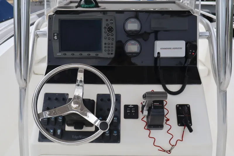 Slide: The Image of Edgewater 225CC 2004 boat console with steering wheel, navigation system, and controls. - 7