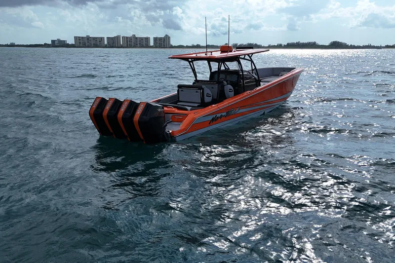 Slide: The Image of 2026 Nor-Tech 390 Sport Center Console boat on water, featuring vibrant orange design. - 10