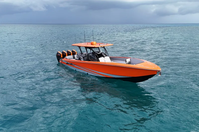 Slide: The Image of 2026 Nor-Tech 390 Sport Center Console boat on open water, vibrant orange design. - 11