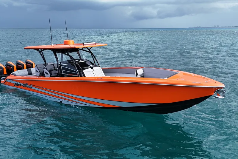 Slide: The Image of 2026 Nor-Tech 390 Sport Center Console boat in vibrant orange on the ocean. - 14