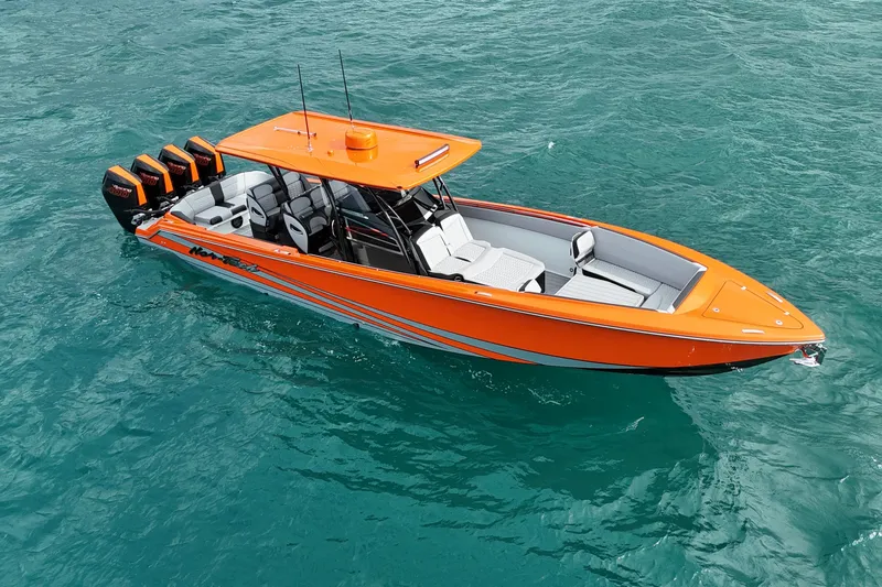 Slide: The Image of 2026 Nor-Tech 390 Sport Center Console boat in vibrant orange on clear blue water. - 15