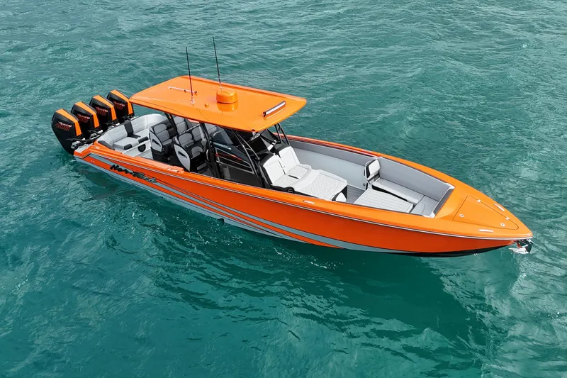 Slide: The Image of 2026 Nor-Tech 390 Sport Center Console in vibrant orange on clear blue water. - 16