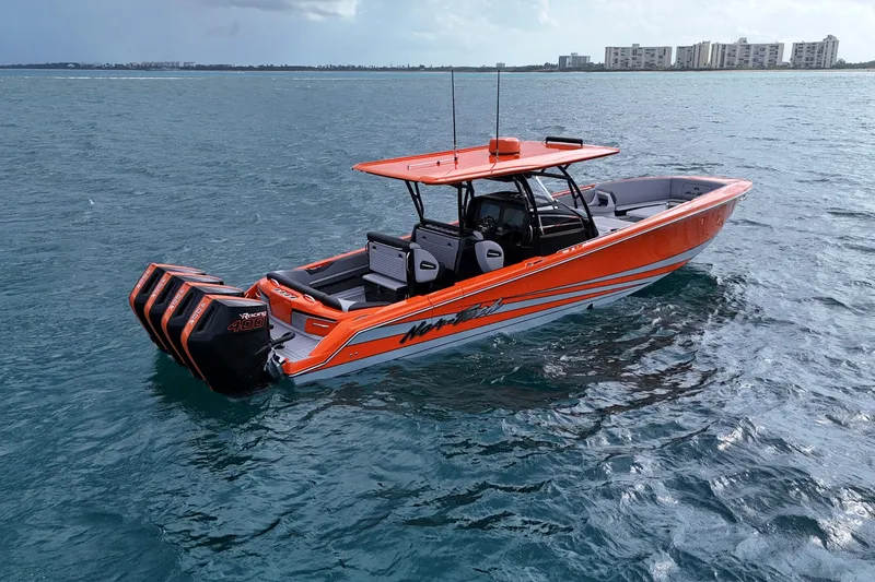 Slide: The Image of 2026 Nor-Tech 390 Sport Center Console boat on open water, featuring vibrant orange design. - 21
