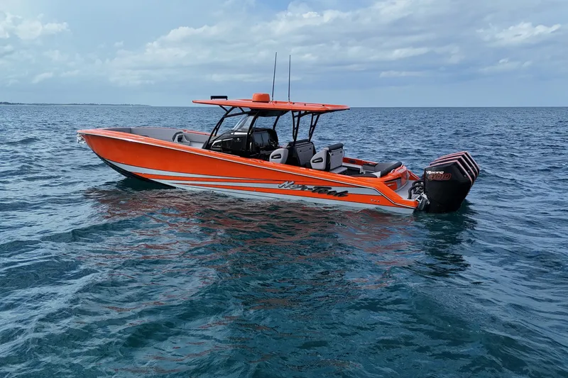 Slide: The Image of 2026 Nor-Tech 390 Sport Center Console boat on open water, vibrant orange design. - 7