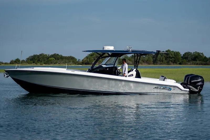The Image of 2026 Nor-Tech 390 Sport Center Console boat on calm water, side view. - 1
