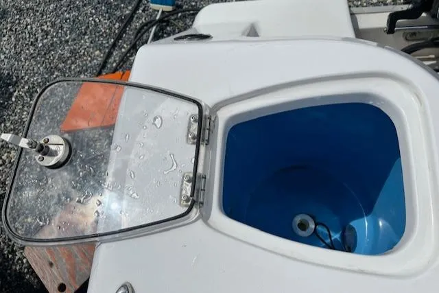 Slide: The Image of Livewell on 2020 Tidewater 272 CC Adventure boat, open lid, blue interior. - 18