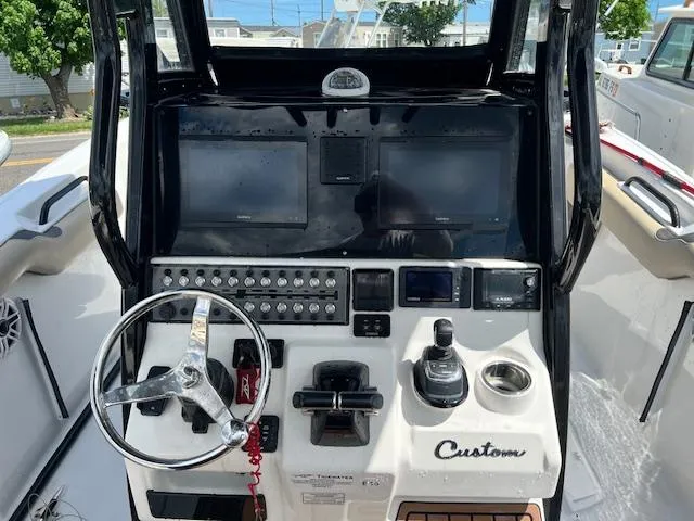 Slide: The Image of 2020 Tidewater 272 CC Adventure boat dashboard with steering wheel and navigation controls. - 4