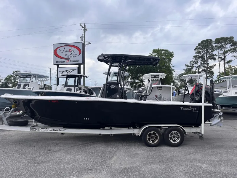 Slide: The Image of 2021 Tidewater 2500 Carolina Bay boat on trailer at dealership, cloudy sky background. - 0