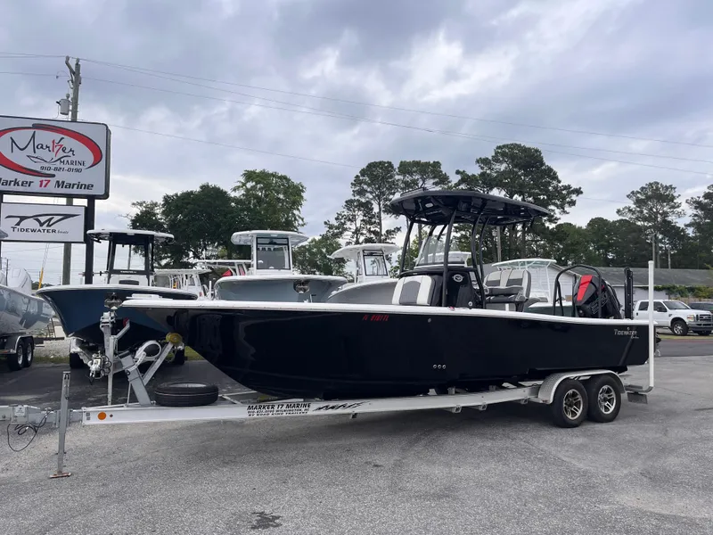 Slide: The Image of 2021 Tidewater 2500 Carolina Bay boat on trailer at dealership, overcast sky. - 1