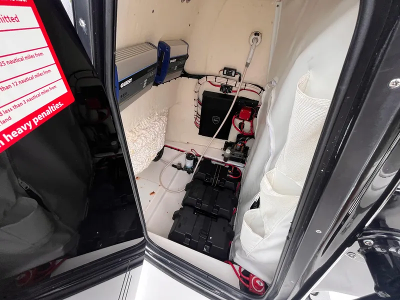 Slide: The Image of Interior view of 2021 Tidewater 2500 Carolina Bay boat's storage compartment with electrical components. - 15