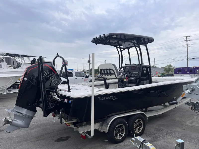 Slide: The Image of 2021 Tidewater 2500 Carolina Bay boat on trailer, featuring a powerful outboard motor. - 4