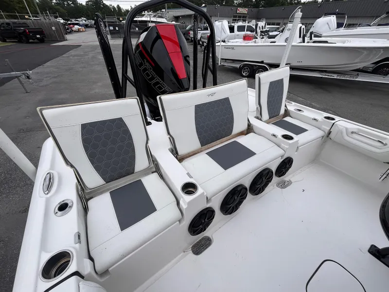 Slide: The Image of 2021 Tidewater 2500 Carolina Bay boat interior with cushioned seating and speakers. - 6