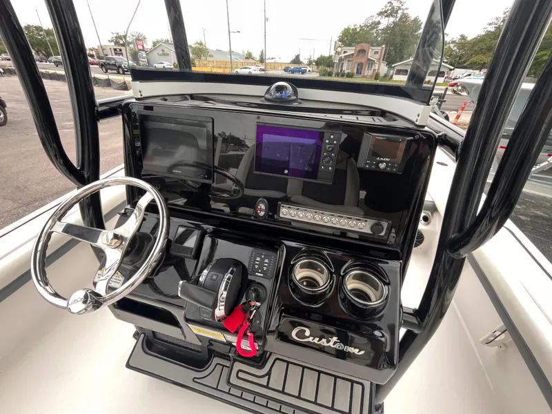 Slide: The Image of 2021 Tidewater 2500 Carolina Bay boat console with steering wheel and navigation controls. - 8