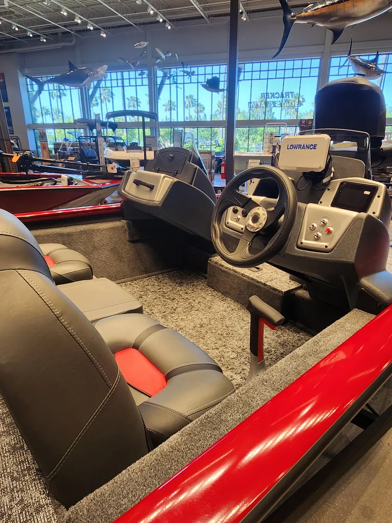 Slide: The Image of 2025 Tracker Pro Team 175 boat interior with steering wheel and seats in showroom. - 2