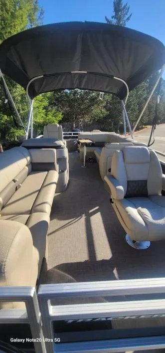 Slide: The Image of 2025 Sun Tracker SportFish 20 DLX pontoon boat interior with seating and canopy. - 2