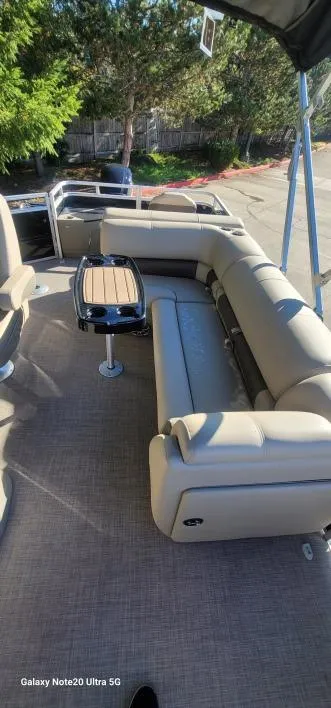 Slide: The Image of 2025 Sun Tracker SportFish 20 DLX pontoon boat interior with beige seating and table. - 3