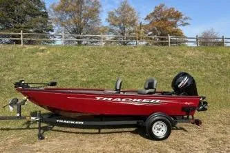 The Image of 2025 Tracker Super Guide V-16 T boat on trailer, parked on grass with autumn trees. - 0
