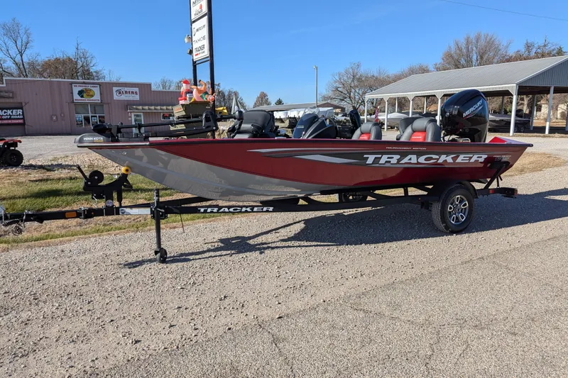 The Image of 2025 Tracker Pro Team 175 boat on trailer, parked outdoors, featuring red and gray design. - 59