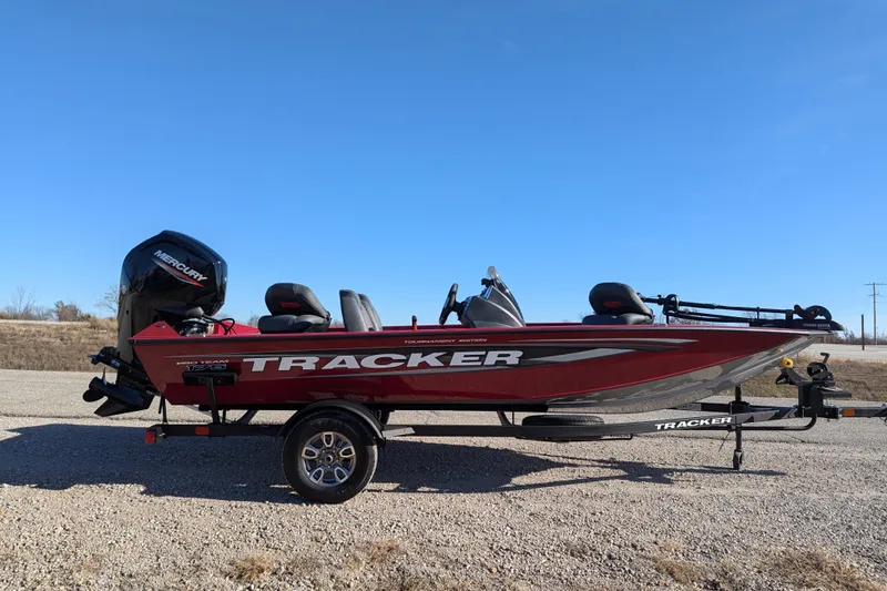 Slide: The Image of 2025 Tracker Pro Team 175 boat with Mercury engine on a trailer, parked outdoors. - 66