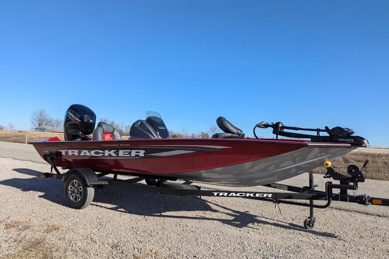 Slide: The Image of 2025 Tracker Pro Team 175 boat on trailer under clear blue sky. - 67