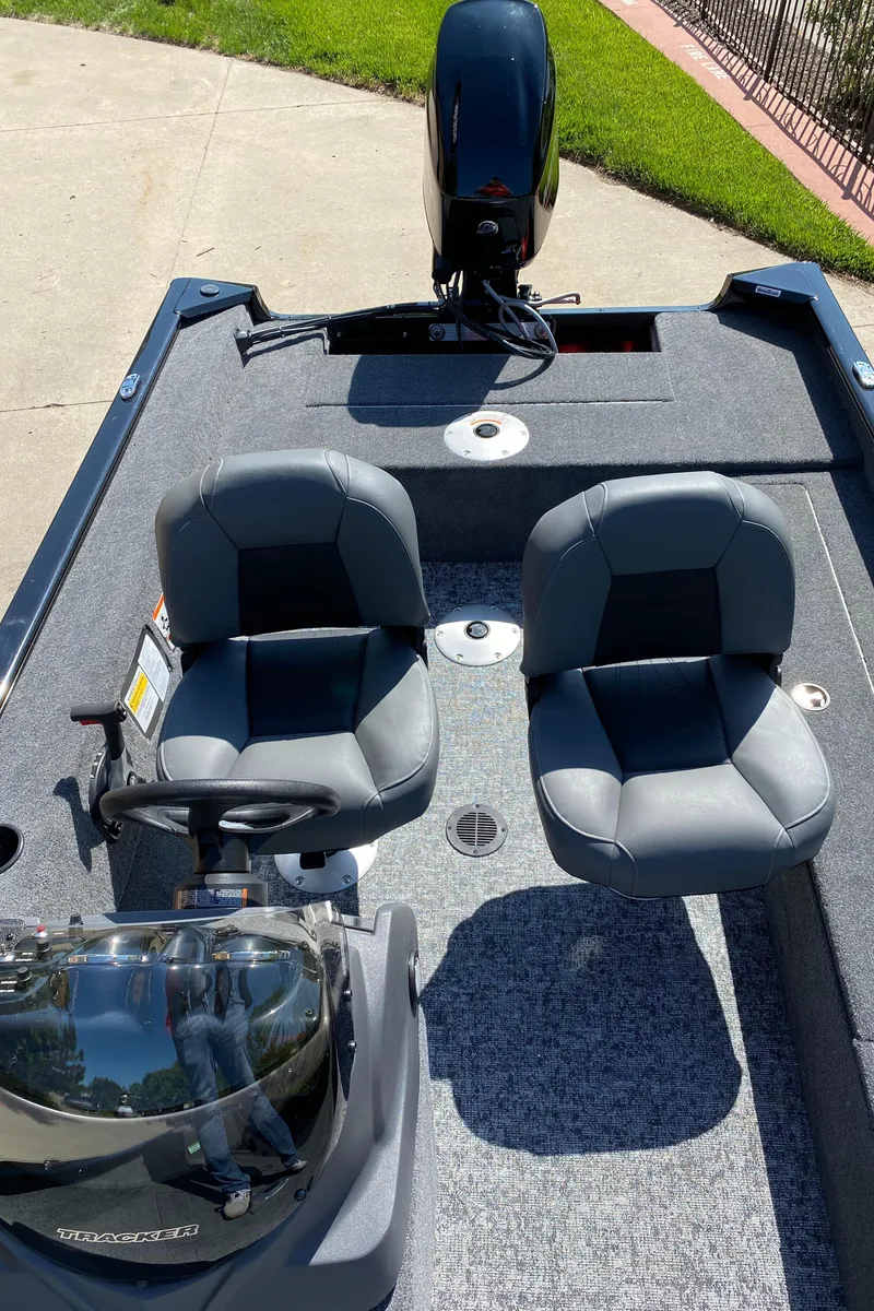 Slide: The Image of 2025 Tracker Super Guide V-16 SC boat with dual seats and motor, parked on concrete. - 4