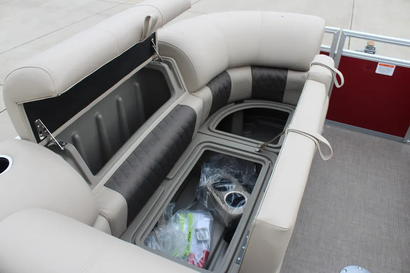 Slide: The Image of 2025 Sun Tracker Party Barge 22 DLX interior storage compartments with beige and black seating. - 12