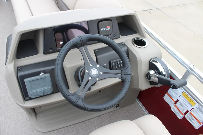Slide: The Image of 2025 Sun Tracker Party Barge 22 DLX steering console with modern controls and cup holder. - 14