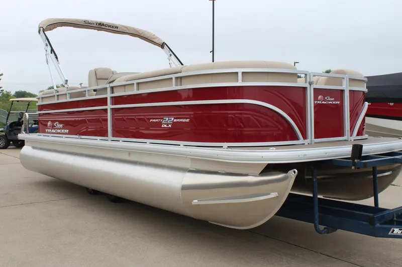 Slide: The Image of 2025 Sun Tracker Party Barge 22 DLX pontoon boat with red exterior on trailer. - 5