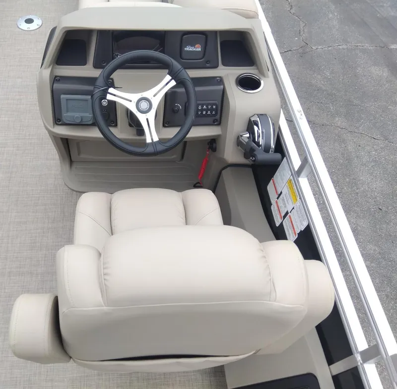 Slide: The Image of 2025 Sun Tracker SportFish 22 DLX helm with steering wheel and beige captain's chair. - 11