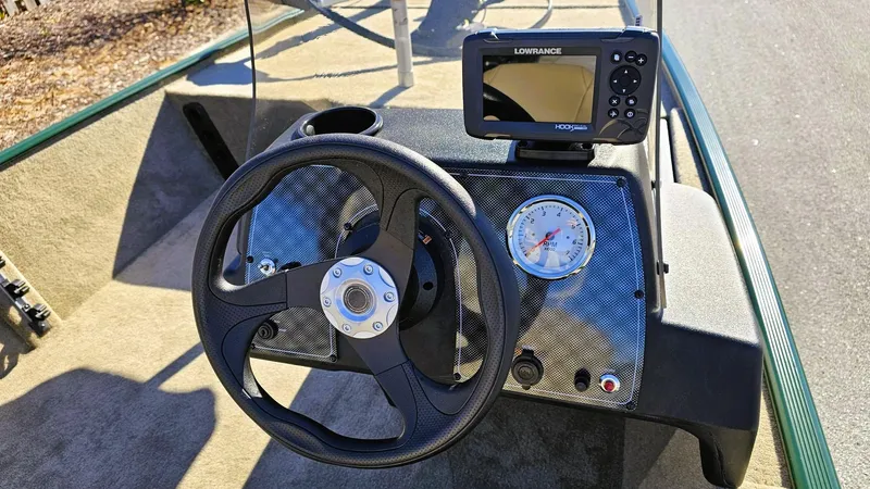 Slide: The Image of 2025 Tracker Bass Tracker Classic Limited dashboard with steering wheel and fishfinder. - 5